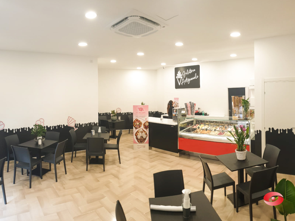 Pasticceria arredata da Zingrillo.com: sala con tavoli e banco vetrina